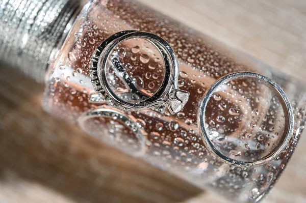 Anillos Boda Cerca Una Botella Perfume Con Gotas Salpicaduras —  Fotos de Stock