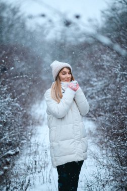 Güzel kız kış ormanlarında yürüyor