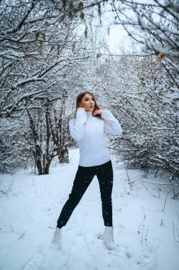 Kış ormanında örülü süveter giyen tatlı sarışın.