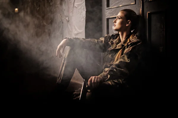 Kvinna med pistol i militäruniform Stockfoto