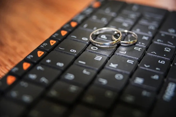 Обручальные кольца на клавиатуре — стоковое фото