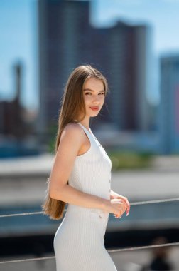 Beyaz kurdeleli elbiseli, uzun saçlı, gevşek poz veren beyaz saçlı, beyaz tenli, beyaz tenli, beyaz tenli kadın.