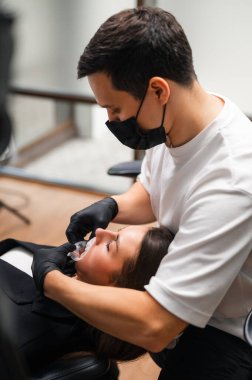 Diş hekimi, Hasta Operatörüne Maske Takarken Yakın Diş Parçası Kullanarak Onarıcı Tedavi Ediyor