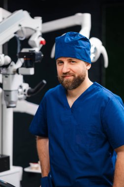 Mavi Önlüklü Cerrah Mikroskop Yanında Hassas Göz Prosedürü, Modern Klinik Işıklandırma, Steril