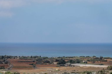 Kıbrıs 'ta sıcak bir günde terk edilmiş tarlalar ve deniz manzarası