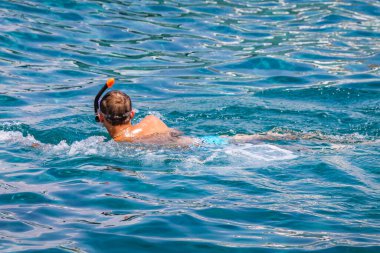 Genç adam maske takmış, maske takmış, soluk almak için şnorkel takıyor.
