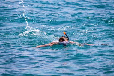 Genç adam maske takmış, maske takmış, soluk almak için şnorkel takıyor.