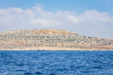 Kıbrıs 'ta masmavi suyla çevrili taştan bir uçurumla çevrili küçük bir durgun su