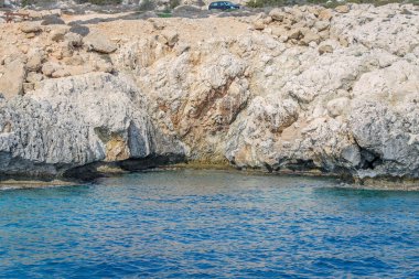 Kıbrıs 'ta masmavi suyla çevrili taştan bir uçurumla çevrili küçük bir durgun su