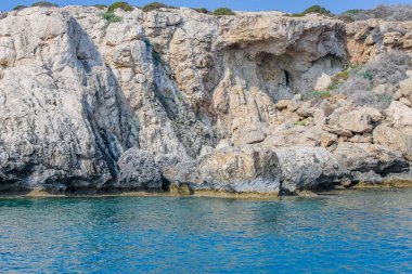 Kıbrıs 'ta masmavi suyla çevrili taştan bir uçurumla çevrili küçük bir durgun su