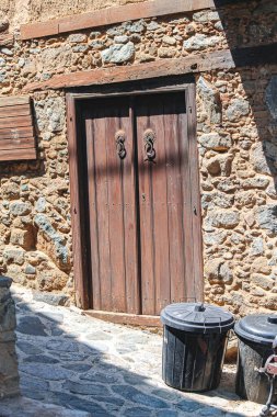 Kakopetria köyünde dar bir sokakta taş bir duvarın içinde.