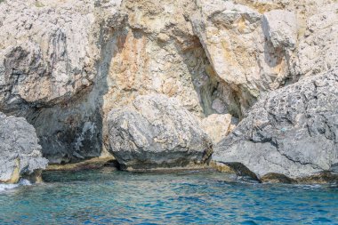 Kıbrıs 'ta masmavi suyla çevrili taştan bir uçurumla çevrili küçük bir durgun su
