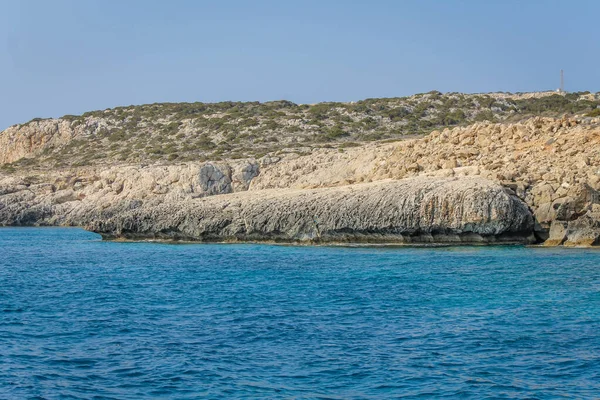 Kleiner Rückstau, umgeben von einer Steinklippe mit azurblauem Wasser in Zypern — Stockfoto