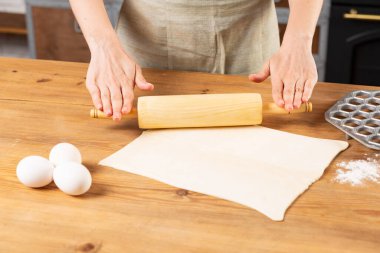 Kadın hamur yapıyor ve mutfakta hamur köftesi pişiriyor.