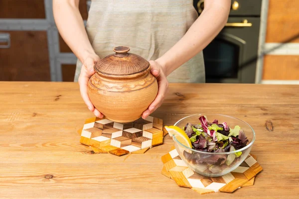 Vrouw Houdt Een Pan Hand Glazen Bord Met Salade Tafel — Stockfoto