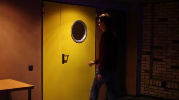 Парень приходит в желтой двери — стоковое видео