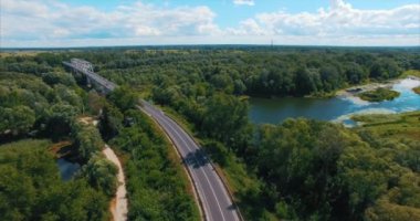 Yolun ortasında orman ve göl üzerinde uçan