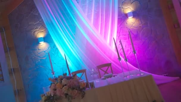 Hochzeitstisch mit schöner Dekoration und rosa Licht — Stockvideo
