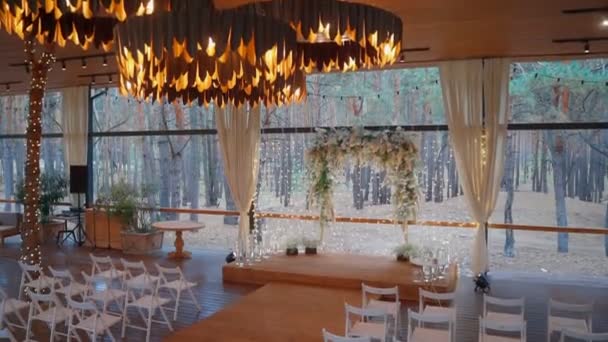 Arco de boda moderno para la ceremonia de la boda con vegetación fresca y luces — Vídeos de Stock