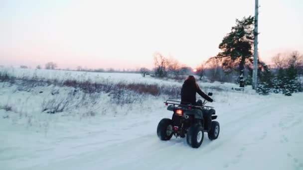 Flicka i fyrhjuling. Vinterfält — Stockvideo