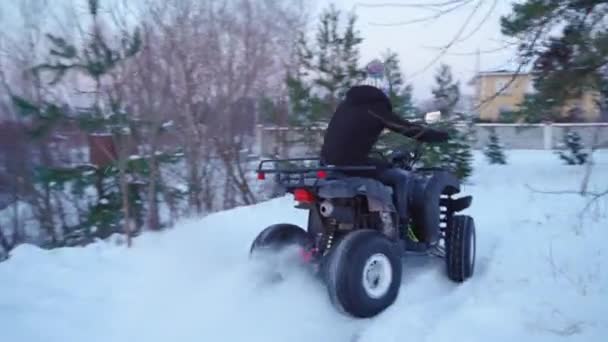 Flicka i fyrhjuling. Vintersnöfält — Stockvideo