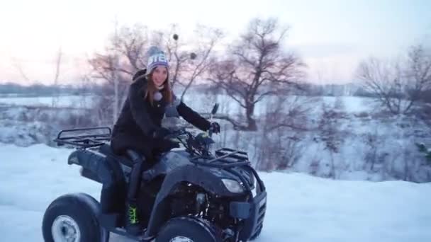 Kvinnor på en fyrhjuling rider i snötäckt tallskog på vintern — Stockvideo