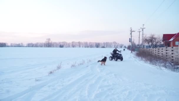 Killen rider på en ATV i det snöiga fältet — Stockvideo