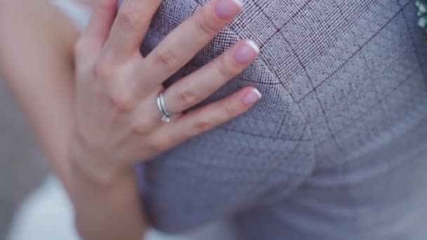 Bride holds her hand over the grooms shoulder — Stockvideo