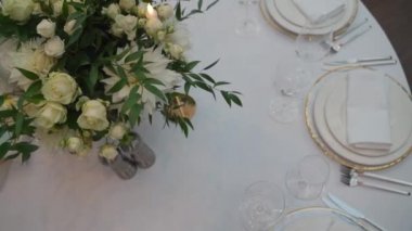 Ortasında çiçekler olan bir ziyafet masası.