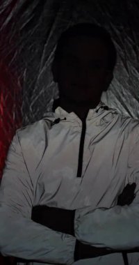 Flaşlı kırmızı ışıkların altında duran ciddi bir siber adamın portresi.