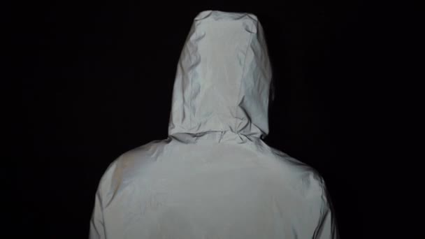 Парень сдает медицинскую маску на черном фоне — стоковое видео