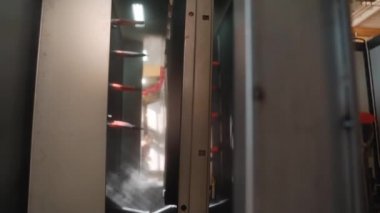 Bir robot fabrikada metali otomatik olarak boyar, büyük bir makine metali boyar.