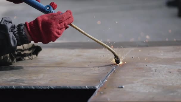 Las luces que salen de la máquina de soldadura utilizada por el trabajador dentro de la fábrica. De cerca. — Vídeos de Stock