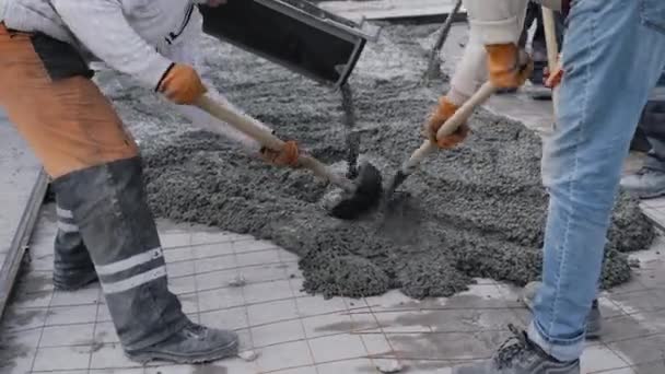 Будівельники переміщують ємність з бетоном і заливають її на будівельному майданчику. Побудова з використанням гігантських механізмів — стокове відео