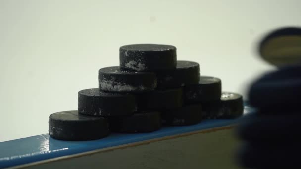 Hockey speler gooit van een piramide van hockey pucks, close-up — Stockvideo