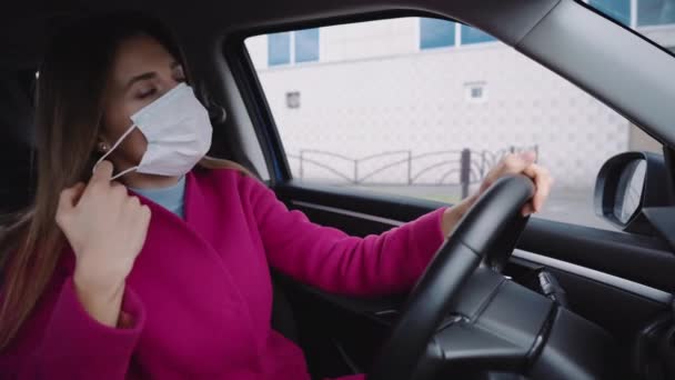 Het meisje doet haar masker af in de auto en glimlacht opgelucht — Stockvideo