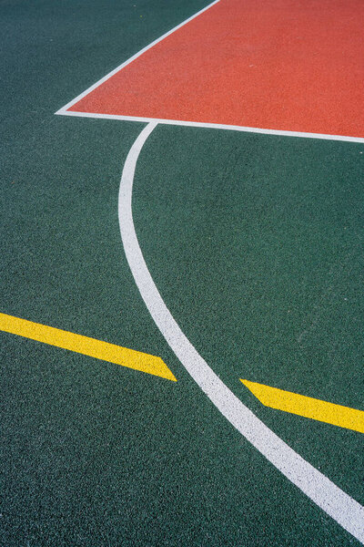 The outdoor basketball court is under the blue sky and white clouds. Close up