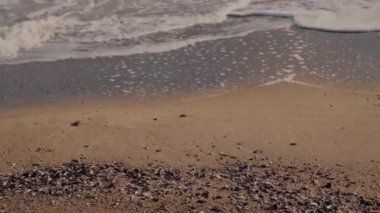 Kumsalda dalgalar, güneşli havalarda, yakın çekim.