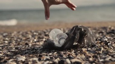 Kızlar plajdan plastik döküntüler toplar.