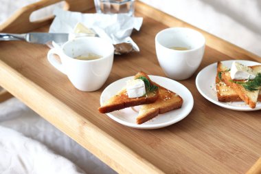 Yatakta Kahvaltı Servisi. Taze kahve, ahşap tepside peynirli kızarmış ekmek. Evde Rahatlama.