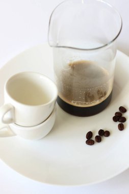 Kahve içiyorum. Beyaz tepside servis edilen siyah kahve ve kupaların kavanozu..