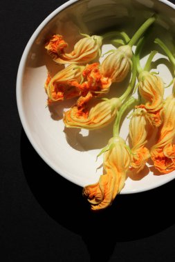 Kabak çiçeği çiçekleri. Kabak çiçekleri beyaz tabakta. Sebzeli İtalyan Makarnası Pişiriyorum.