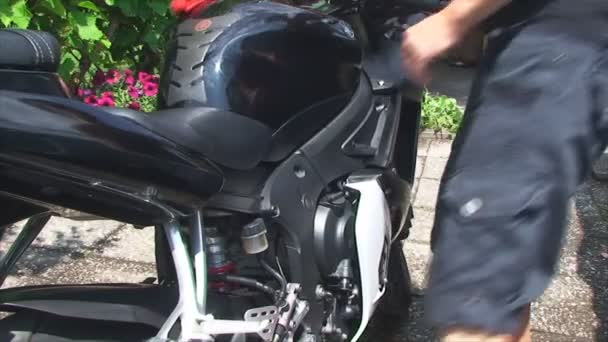 Een man wast motorfiets — Stockvideo