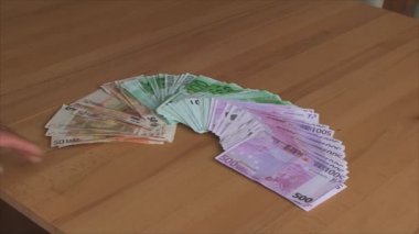 Euro odasındaki masada banknotlar farklı mezheplerin bir hayranı tarafından dağılın