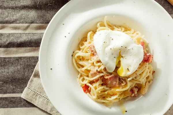 Σπαγγέτι καρμπονάρα με αυγό ποσέ. Ιταλικό φαγητό — Φωτογραφία Αρχείου