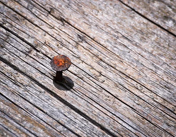 Rusty nail in an old wooden board — Stock Photo, Image