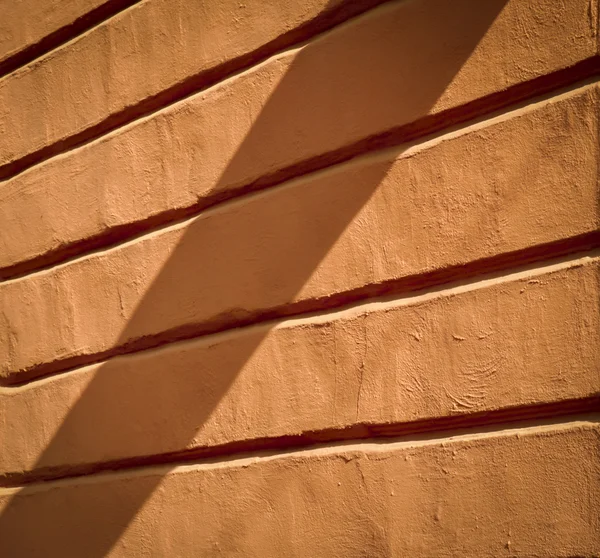 Old orange wall with relief in the shade — Stock Photo, Image