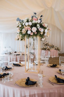 Çiçeklerin ve aksesuarların düğün süslemeleri masada.