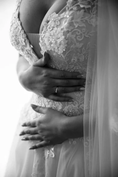 Gyönyörű menyasszony, szürke háttérrel. A nő egy hosszú esküvői ruha csipkével és nyitott háttal. Csokor a kézben. — Stock Fotó