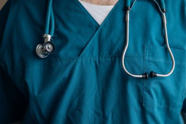 Doktor elinde bir fonendoskop tutuyor. Tıp üniformalı doktor. Cerrah.